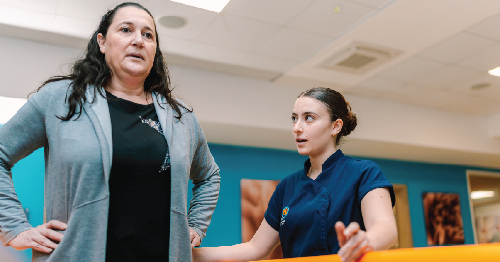 Physiotherapist supporting a patient during rehabilitation exercises at Revive Physio Centre in Malta